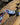 'Sentient' Lanyard by Indigenous Student Hollie Johnson for RMIT University. Lanyard displayed on a log with an up close view of the RMIT Logo.