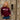 The RMIT Store's Burgundy Signature Hoodie featuring a white screen printed RMIT logo. Modelled by female standing inside RMIT buildings  photographed front on.
